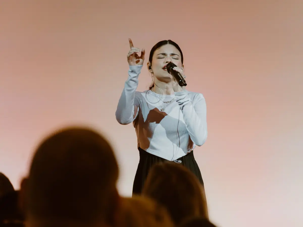 A worship leader singing at Christ's Family Church